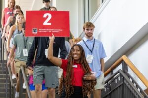 A UGA New Student Orientation Leader holds up a #2 sign.