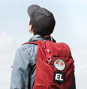 person wearing a backpack with an EL button