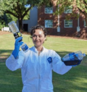 A UGA Office of Sustainability intern holds plastic water bottles.