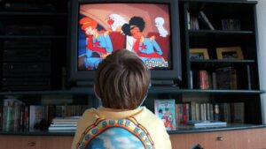 A kid sits and watches TV.