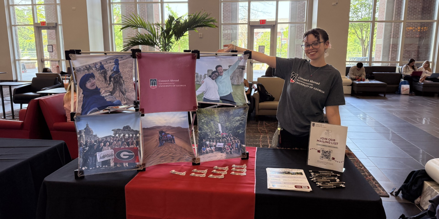 ELCA Ambassadors Adriana Churchill, an ELCA Ambassador, posing with a Connect Abroad table at an event