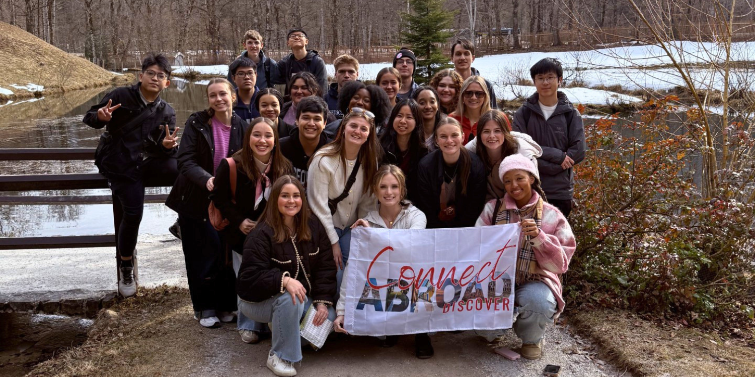 ELCA Impact 30 students posing in front of a Bavarian landscape holding a Connect Abroad Discover flag